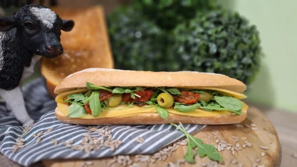 Broodje Geloei: vers belegd broodje met oude kaas, rucola, zongedroogde tomaatjes, groene olijven en zwarte tapenade.