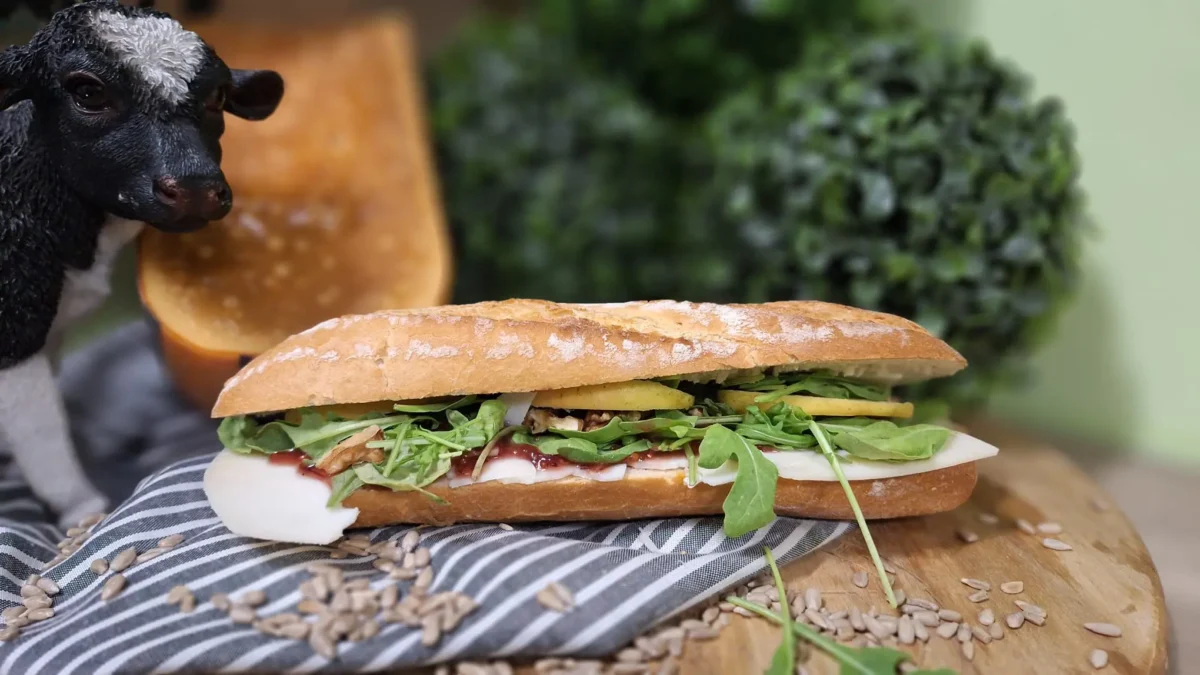 Broodje Gemekker: vers belegd broodje met milde geitenkaas, rucola, walnoten, appel en cranberrydip.