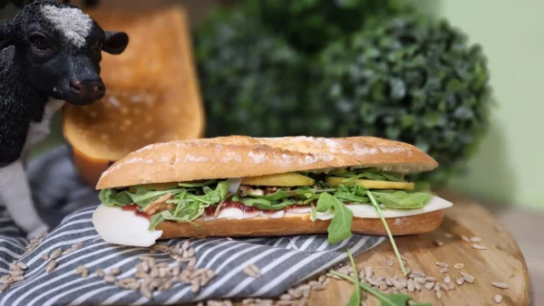 Broodje Gemekker: vers belegd broodje met milde geitenkaas, rucola, walnoten, appel en cranberrydip.