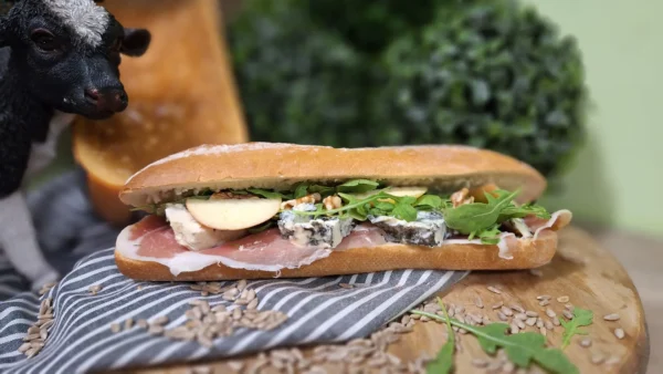 Broodje Hemels Blauw: vers belegd broodje met boerenham, Saint Agur, rucola, walnoten en appel.